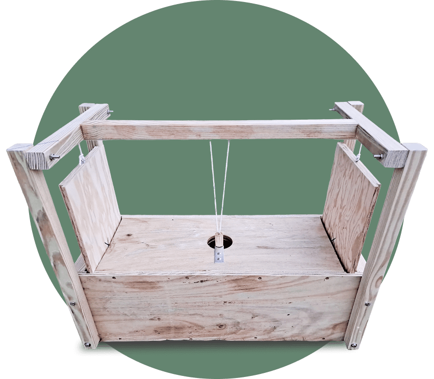 Wooden guillotine-style mousetrap on green background.